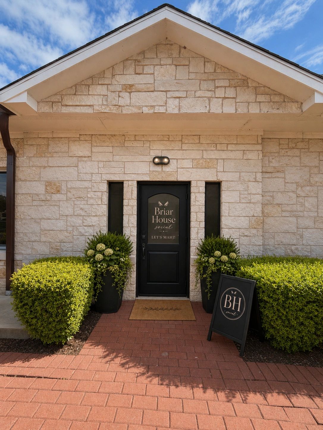 The Briar House Social doorway framed by stone walls and greenery